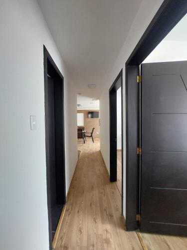 an open hallway with black doors and wooden floors at Espectacular vista en Ambato in Ambato