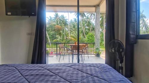 Un dormitorio con una cama y un balcón con mesa y sillas. en Oscar bungalow, en Ban Madua Wan