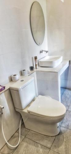 a white bathroom with a toilet and a sink at Oscar bungalow in Ban Madua Wan