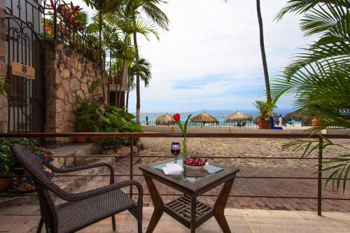 a table with a red rose on it next to two chairs at Vallarta Shores Beach Hotel in Puerto Vallarta