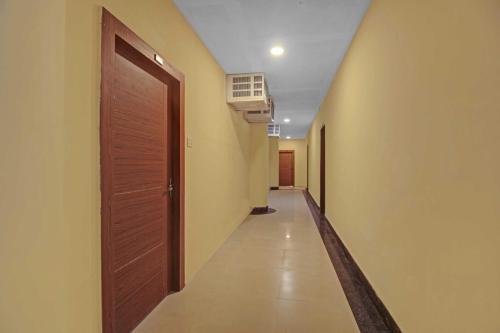 a hallway with a wooden door and a hallway sidx sidx sidx at Super Collection O Hotel Aqua Villa Near Netaji Subhash Chandra Bose International Airport in Kolkata