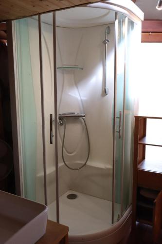 une douche avec une porte vitrée dans une salle de bain dans l'établissement Les Yourtes du Perche, à Coulonges-sur-Sarthe
