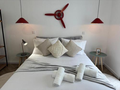 a bedroom with a white bed with a clock on the wall at Casa do Aviador in Relva