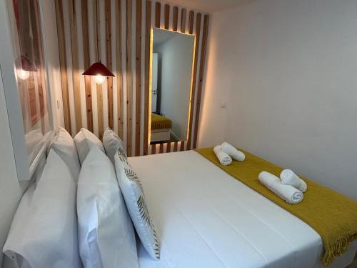 a bedroom with a large white bed with two pillows at Casa do Aviador in Relva