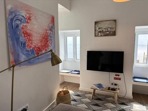 a living room with a flat screen tv on a wall at Casa do Aviador in Relva