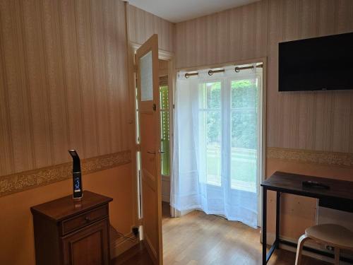a room with a window and a television on the wall at Chambre d'hote les frérots in Lurcy-le-Bourg