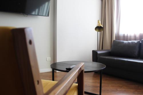 a living room with a black couch and a table at Mercure Rosario in Rosario