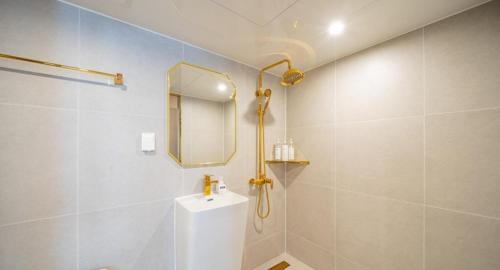 a bathroom with a shower and a sink and a mirror at Masan Den Basta Gyeongnam Uni in Changwon