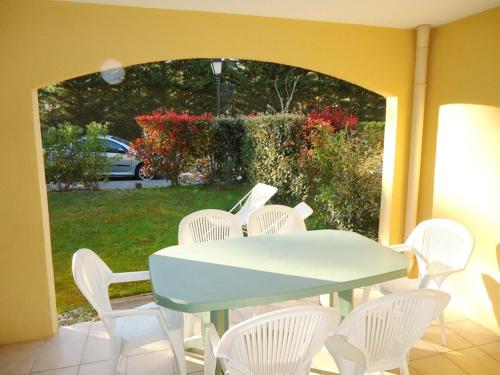 une table et des chaises blanches sur une terrasse avec une table et une table dans l'établissement Appartement 3 Chambres PISCINE 500M PLAGE, à Cavalaire-sur-Mer
