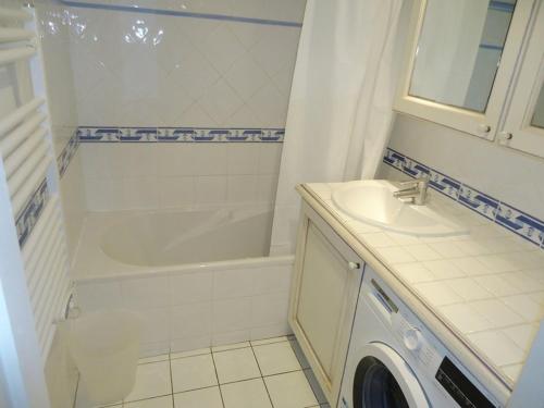 La salle de bains est pourvue d'une baignoire, d'un lavabo et d'un lave-linge. dans l'établissement Appartement 3 Chambres PISCINE 500M PLAGE, à Cavalaire-sur-Mer