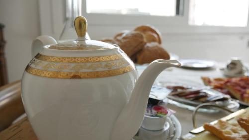 a white tea kettle sitting on a table with bread at Nonna Rina b&b in Savona