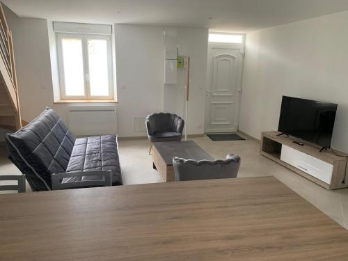un salon avec un canapé et une télévision dans l'établissement Appartement bien placé, à Hermonville