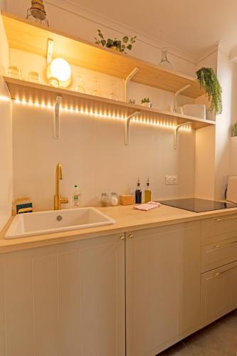 une cuisine avec des armoires blanches et un évier dans l'établissement LE NID Hyper-centre - Stadium - PARKING & WiFi, à Toulouse