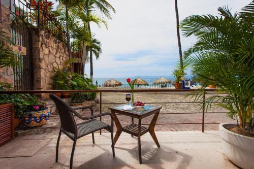 a table and chairs on a patio with a view of the beach at Vallarta Shores Beach Hotel in Puerto Vallarta