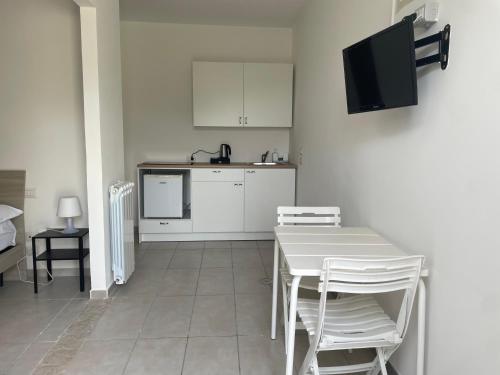 a kitchen with white cabinets and a table and chairs at Zia Bi Bed and Breakfast in Naples