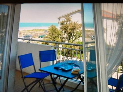une table et des chaises sur un balcon avec vue sur l'océan dans l'établissement Appartement vu mer, à Notre-Dame-de-Monts
