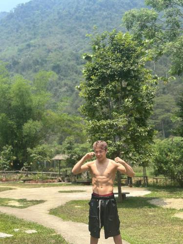 a shirtless young man standing on a dirt road at Ngoặng homestay - phòng nghỉ trọ in Chiêm Hóa