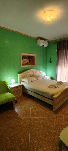 a green bedroom with a bed and a green wall at Er Centurione in Rome
