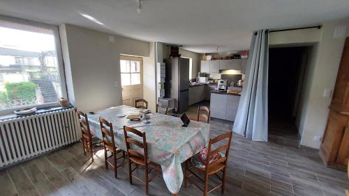 une cuisine et une salle à manger avec une table et des chaises dans l'établissement Maison de village, à Corbonod