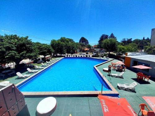 a large swimming pool with chairs and umbrellas at Nuevo Hotel Villa Giardino in Villa Giardino