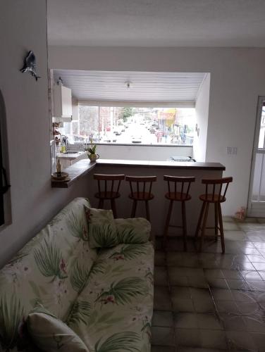 een woonkamer met een bank en een keuken met een tafel bij Apartamento Arara Azul in Cabo Frio