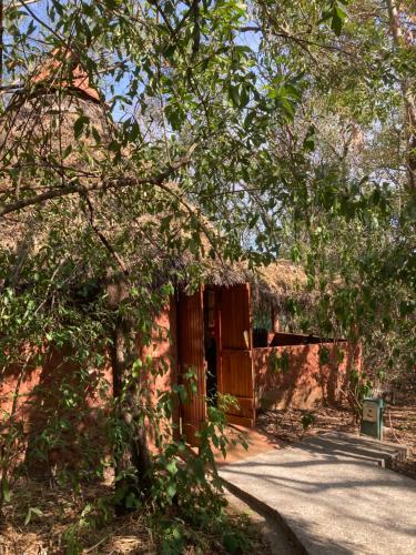 a wooden gate to a building with a road at Mundo Milo Eco Lodge in Playa Junquillal