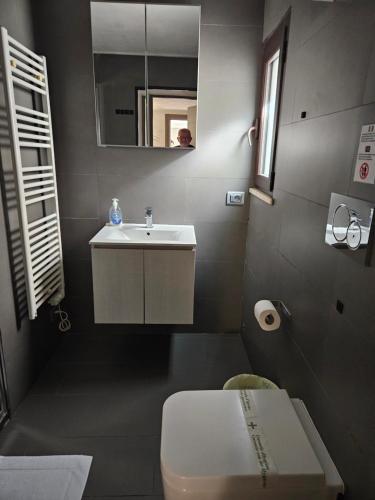 a bathroom with a white sink and a toilet at Sweet Pisa Guesthouse in Pisa