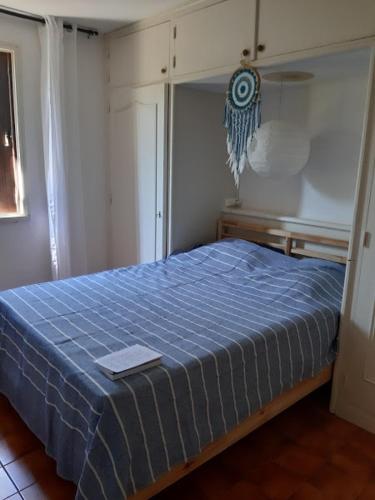 - une chambre avec un lit doté d'une couverture bleue dans l'établissement Une résidence au calme à 600 m des plages de La Ciotat, à La Ciotat