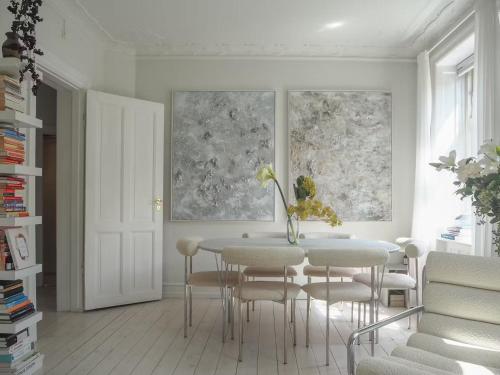 a white dining room with a table and chairs at Artsy & Bright - Scandinavian Apartment in Copenhagen