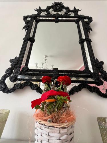 a basket with flowers in front of a mirror at Villa Bella Vita in Seeboden