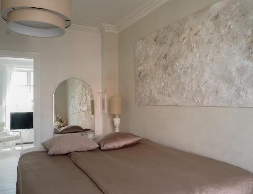 a bedroom with a bed with two pillows on it at Artsy & Bright - Scandinavian Apartment in Copenhagen
