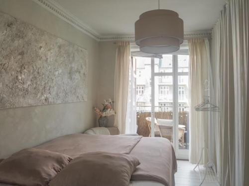 a bedroom with a bed and a large window at Artsy & Bright - Scandinavian Apartment in Copenhagen