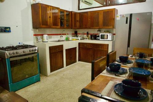 a kitchen with wooden cabinets and a stove and a table at Chelita House a 5 minutos de la Plaza de Armas in Iquitos