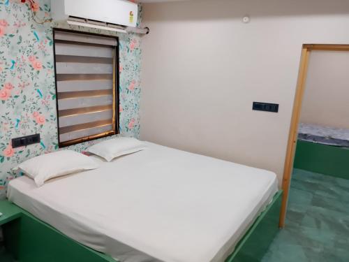 a small bedroom with a bed and a window at Swagan Home Stays Air Conditioned Deluxe ONE BED ROOM Studio Apartment in Visakhapatnam