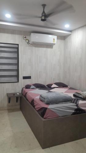 a bedroom with a large bed with a fan at Swagan Home Stays Air Conditioned Deluxe ONE BED ROOM Studio Apartment in Visakhapatnam