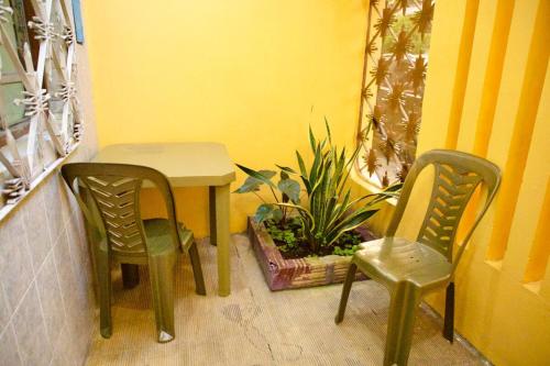 a table and two chairs and a plant in a room at Chelita House a 5 minutos de la Plaza de Armas in Iquitos