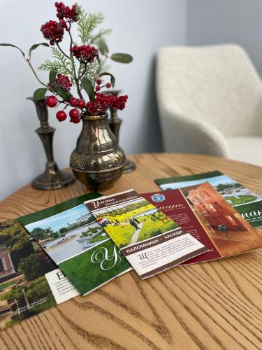 a wooden table with brochures and a vase with flowers at Нова однокімнатна квартира in Umanʼ