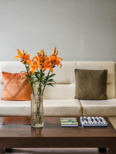 a vase of orange flowers sitting on a coffee table at Hotel Vale Verde in Furnas
