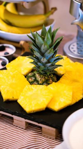 a pineapple cut into slices on a black plate at Americana Beach House in Rimini