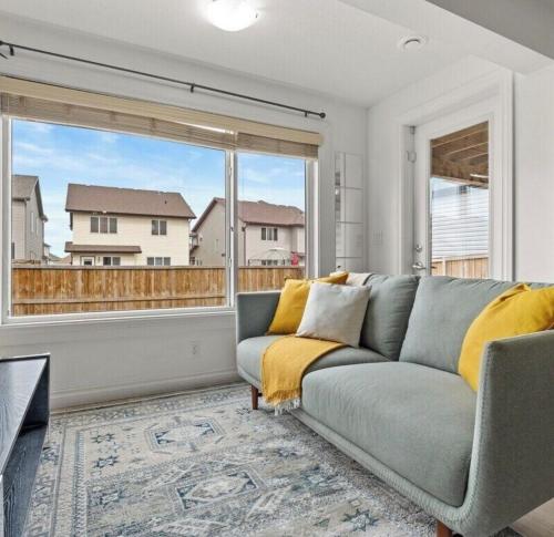 a living room with a couch and a large window at 2 Bedroom walkout basement suite in Okotoks