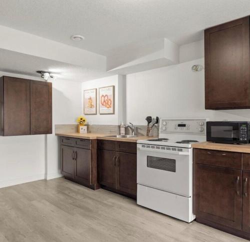 a kitchen with white appliances and wooden cabinets at 2 Bedroom walkout basement suite in Okotoks