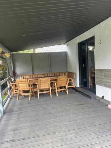 a porch with wooden benches on a deck at Mazury Dom Oskar nad jeziorem Sasek Wielki z jakuzzi in Szczytno