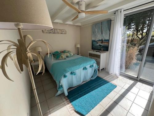 une chambre avec un lit avec un ventilateur et une fenêtre dans l'établissement Villa Entre lac, forêt, océan, à Biscarrosse
