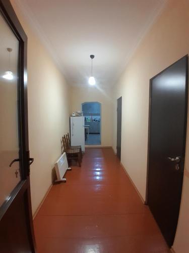 a hallway of a room with a door and a kitchen at Kachal guest house in Mestia