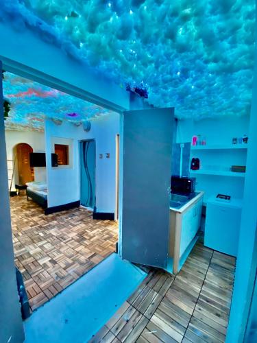 une cuisine aux murs bleus et un plafond aux nuages dans l'établissement Bubble Room Jaccuzi,Sauna,Hammam, à Béziers