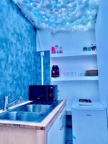 une cuisine avec un évier et un micro-ondes dans l'établissement Bubble Room Jaccuzi,Sauna,Hammam, à Béziers