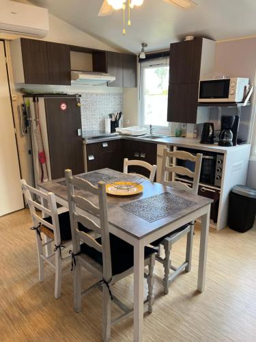 une cuisine avec une table et des chaises dans une cuisine dans l'établissement MOBIL HOME 200m de la mer, à Hyères