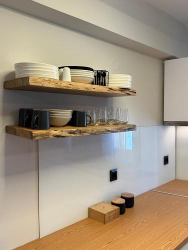a kitchen with wooden shelves with plates and dishes at Apellou Apartments in Vathý