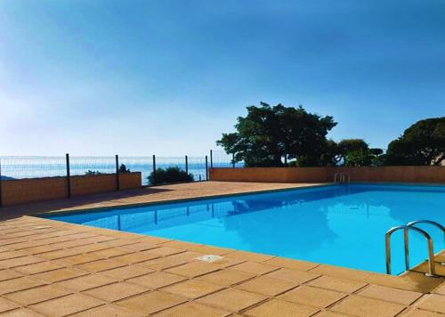une piscine avec l'océan en arrière-plan dans l'établissement La Terrasse de Marie - superbe vue, terrasse, piscine, à Cavalaire-sur-Mer