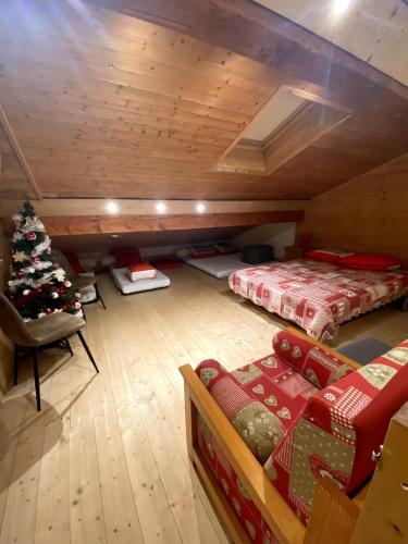 Cette chambre mansardée comprend deux lits et un arbre de Noël. dans l'établissement Manigod, en route pour les vacances !, à Manigod